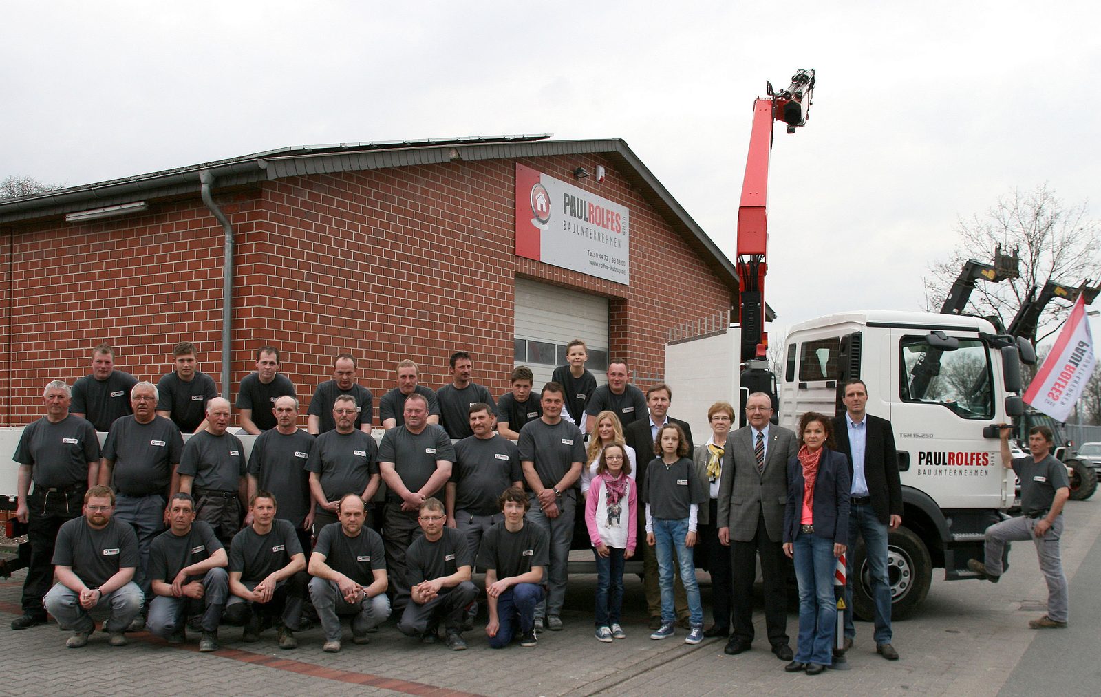 Belegschaft und Familie Rolfes vor der Lagerhalle
