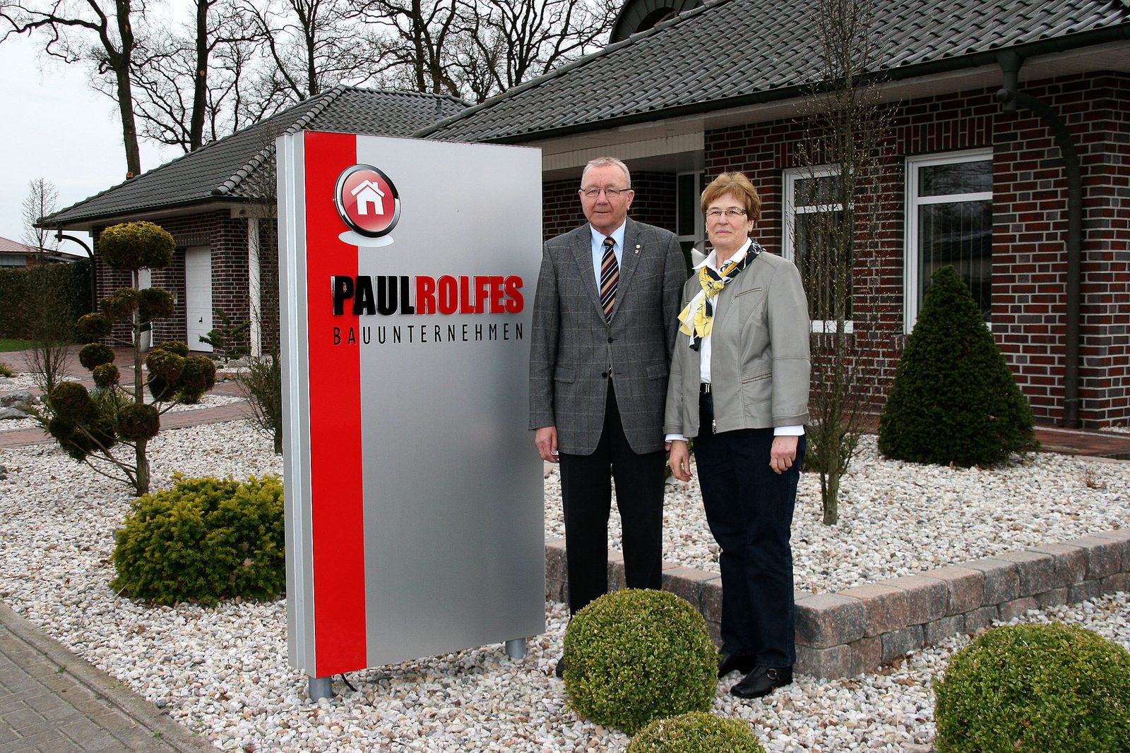 Das Gründerehepaar am Firmenschild
